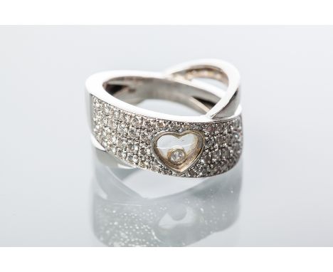 DIAMOND HEART DESIGN RING 
in the style of Chopard, of crossover design, with a central heart shaped section with a floating 