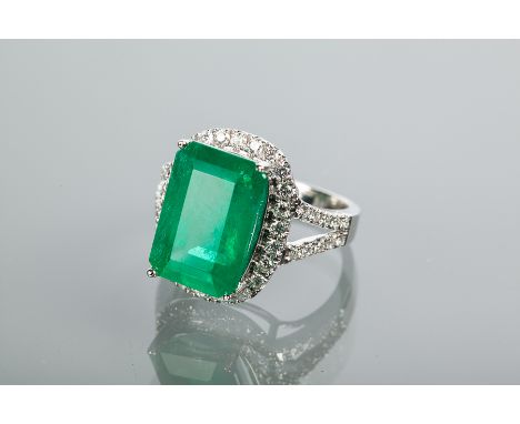 EMERALD AND DIAMOND RING
set with an emerald cut emerald, surrounded by a crow of brilliant cut diamonds, on diamond set bifu