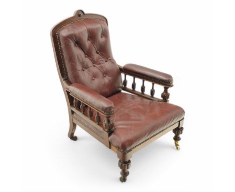 Late Victorian mahogany open armchair, arched cresting rail decorated with turned roundel, upholstered in buttoned burgundy l