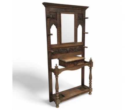 Victorian heavily carved oak hall stand, the moulded cornice over rectangular bevelled mirror flanked by open archways and pa