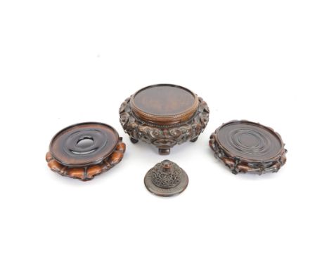 Three 19th century Chinese carved hardwood vase stands, the largest example of circular form with scroll carved and part pier