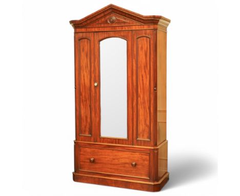 Mid-19th century figured mahogany wardrobe, the sloped architectural pediment over mirror glazed door and panelled uprights, 
