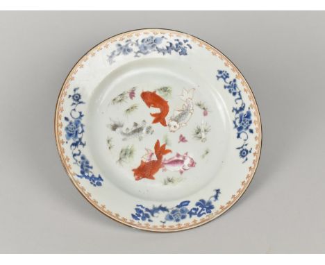 A Chinese Qing Dynasty Porcelain Plate Decorated in the Famille Rose Palette with Five Carp Swimming Amongst Waterweeds, the 