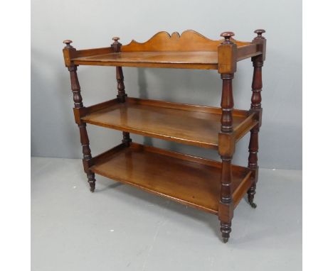 A Victorian mahogany three-tier buffet, with turned supports and brass casters. Width  107cm, height 106cm, depth 45cm.