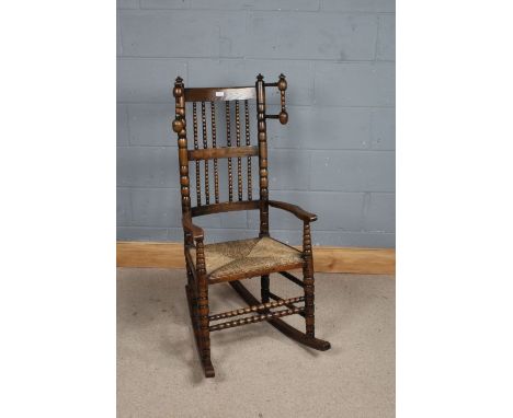 Edwardian rocking chair, with bobbin turned spindle back and arms, rush seat, on bobbin turned legs