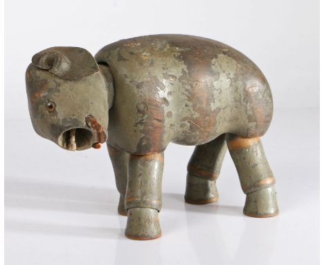A late 19th/early 20th century grey painted wooden articulated elephant toy, with glass eyes and leather ears, trunk missing,