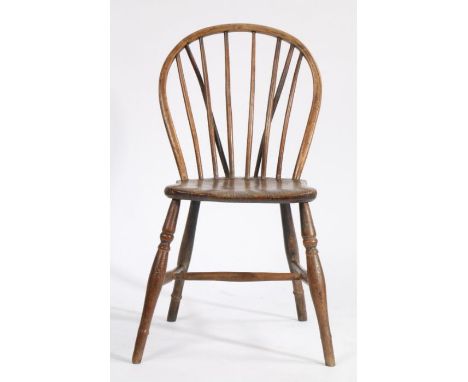 A 19th Century stick back dining chair, the arched cresting rail above turned spindles and a solid dished seat, raised on tur