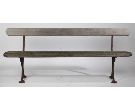 An early 20th Century cast iron garden bench, the pierced scroll decorated ends with trefoil pad feet, later back and seat, 2