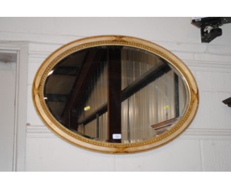 An oval gilt framed and bevel edged wall mirror 