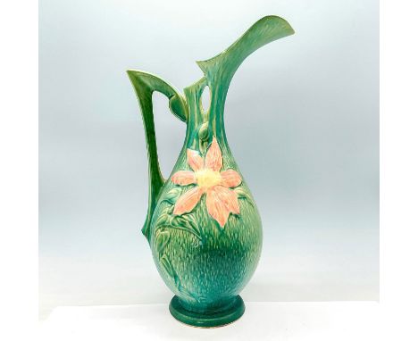 This striking ceramic pitcher, adorned with beautiful green clematis flowers and graceful curves, exudes elegance and charm. 
