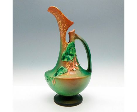 Matte finished pitcher is colored in green and tawny brown with leaf design. Dimensions: 5"L x 5"W x 10"HCondition: Age relat