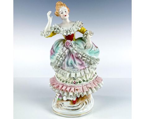 Porcelain figurine modeled as woman in frilled French ball gown. Pink, blue, yellow, red, and gold gilt details.Unmarked. Thi