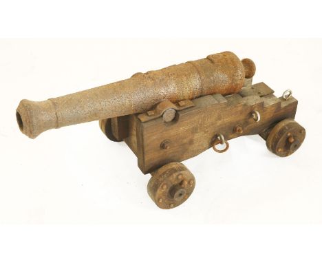 An iron signalling cannon, with cast crown over BP, on later wooden trolley, 63cm barrel 72cm overall  31cm high