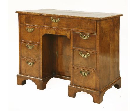 A George II walnut kneehole desk, with herringbone banding, the rectangular top over a long frieze drawer and a central cupbo