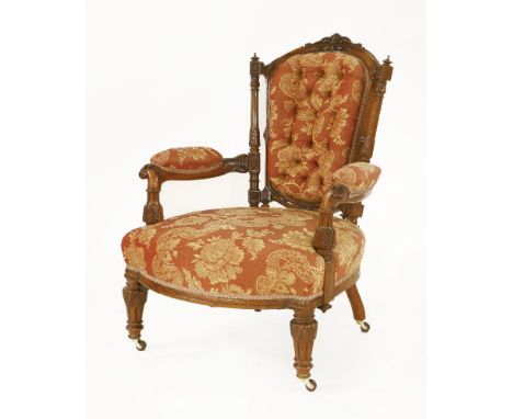 A Victorian walnut open armchair,the frame finely carved with leaves and foliage, with button back, on fluted turned legs and