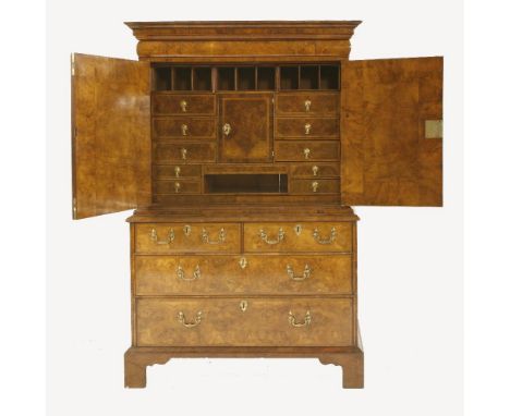 A Queen Anne walnut cabinet,the top section with a cushion moulded drawer over two doors, enclosing a central cupboard enclos