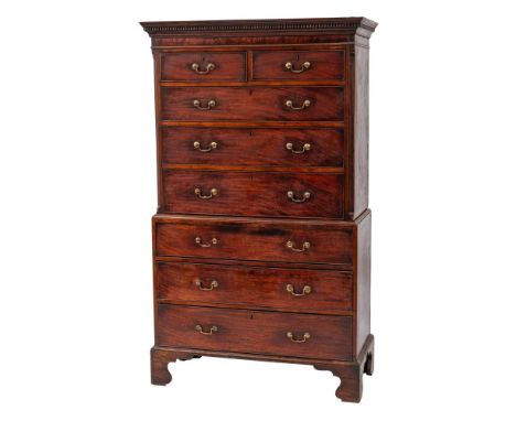 A George III mahogany chest on chest:, the upper part with a moulded dentil cornice and fluted canted angles, containing two 