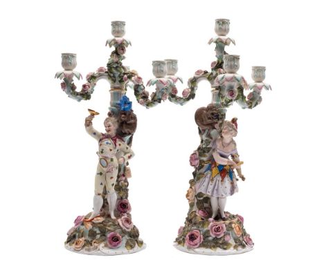 A pair of Sitzendorf four-light candelabra: modelled as male and female jesters with monkey assistants, the branches, columns