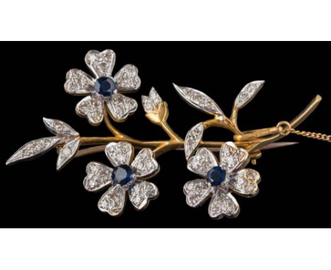 An 18ct gold, sapphire and diamond floral spray brooch: approximately 54mm long, 12gms gross weight. 