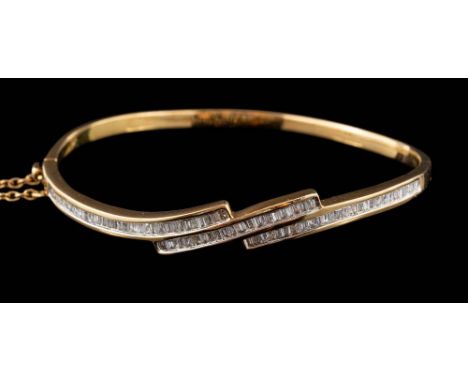 A modern diamond mounted cross-over hinged bangle: channel-set with baguette and keystone-shaped diamonds estimated to weigh 