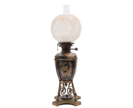 A Doulton Lambeth stoneware oil lamp by Mark V. Marshall: decorated with mythological creatures, pine cones and foliage withi