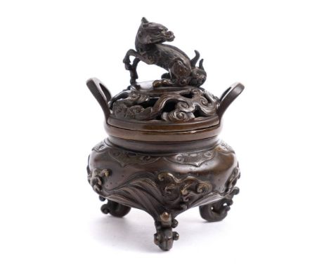 A Japanese bronze koro and cover: the pierced shallow domed lid surmounted with a dragon, with loop handles to the rim, the s