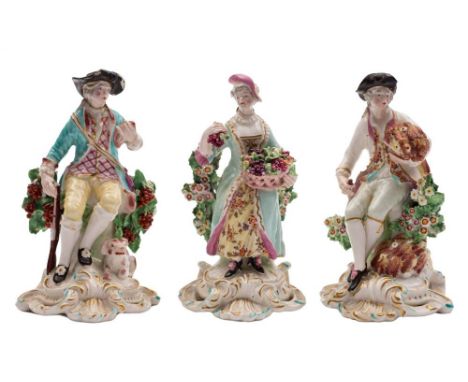 A pair of Derby bocage figures of the Seasons and a similar figure of a sportsman: Summer holding a sheaf of corn and a hook,
