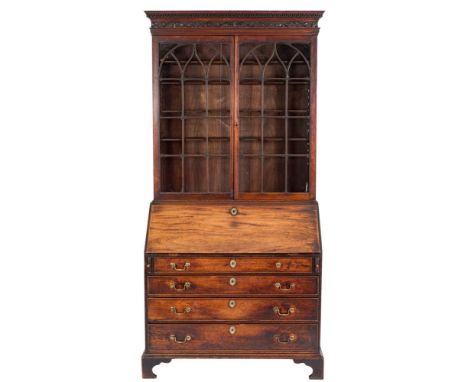 A George III mahogany bureau bookcase:, the upper part with a moulded dentil cornice and carved trailing foliate frieze, fitt