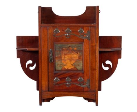 Shapland and PetterA mahogany and oxidised metal mounted wall cabinet:, of shaped outline, having open and canted shelves, th