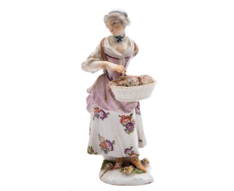 Two Meissen figures: the first of a shepherdess, wearing a yellow bodice, with  flowers in her apron and a ewe at her feet, o