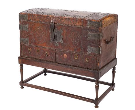 A 19th Century Continental leather covered and steel and brass mounted domed trunk on a later oak stand:, with brass studded 