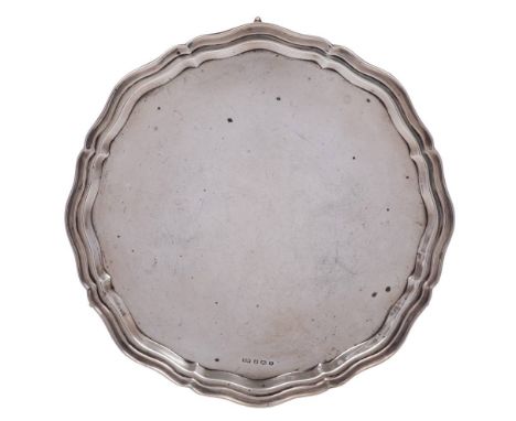 A George VI silver salver, maker Viners Ltd, Sheffield, 1939: of circular outline with piecrust border, and raised on three s