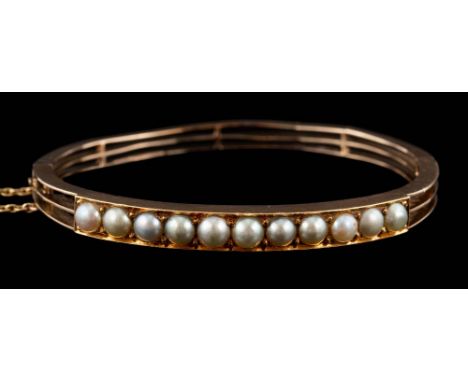 A 19th Century gold and split-pearl mounted hinged bangle: approximately 57mm inside diameter, 14gms gross weight. 