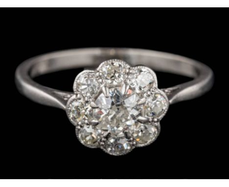 A platinum and diamond circular cluster ring: with central round old, brilliant-cut diamond claw-set within a surround of sma