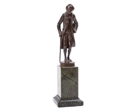 After A. Schmidt, a bronze study entitled 'Kindermann': the figure in frock coat, holding a walking stick in one hand and a b