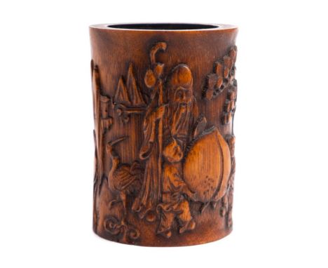 A Chinese 'Shoulao' bamboo brush pot: carved with Shoulao resting one hand on a giant peach supported by two attendants, seal