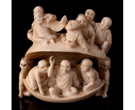 A large Japanese carved ivory netsuke of a clam, signed Meigyoku: with monks in the interior and exterior, the clam held open