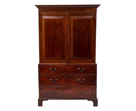 A 19th Century mahogany linen press:, the upper part with a moulded dentil cornice, fitted with sliding trays enclosed by a p