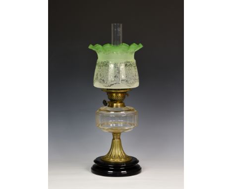 A late 19th century brass oil lamp, the green floral etched glass shade above a pierced burner, stamped 'British made', above