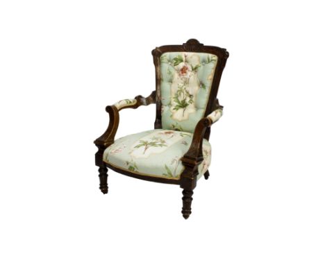 A Victorian mahogany carved showframe open armchair, floral print upholstery on turned forelegs with brass and pottery castor