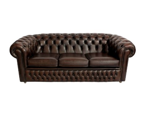 A brown leather button backed Chesterfield sofa, with brass studded scroll arms, 78 x 35in. (198 x 89cm.) 