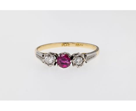 An 18ct gold, ruby and diamond 3 stone ring, featuring a round cut ruby to the centre, with a brilliant cut diamond to each s