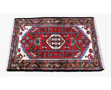 A small Turkoman rug, late 20th century, the red hexagonal field with ivory spandrels and single ivory hexagonal medallion, w