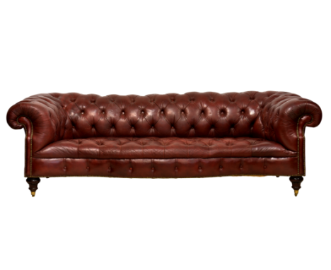 A Victorian leather serpentine Chesterfield sofa, in dark red buttoned leather, raised on turned walnut front legs with brass