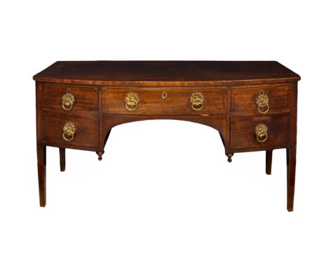 A George IV mahogany bow fronted sideboard, the five ebony strung drawers with floral gilt brass loose ring handles, around a