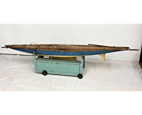 A large 1960s pond yacht, 'Heron', with painted wooden hull, teak-style planked deck with central mahogany rib, masts with wi