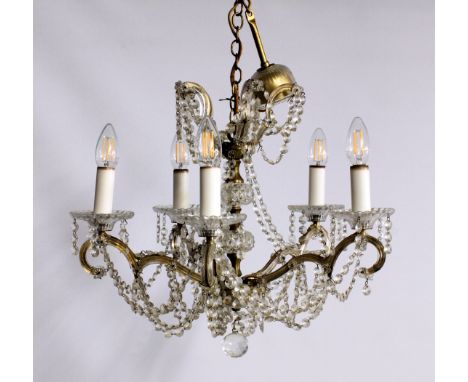 A pair of gilt metal and cut glass five light chandeliers, mid-20th century, the five scrolled arms issuing from a gilt metal