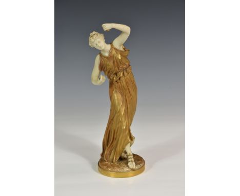 A Royal Worcester porcelain dancing figure, circa 1903, modelled standing playing castanets, wearing flowing gold dress and s