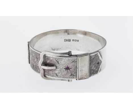 A Victorian style silver bangle, Bracelon Ltd., Birm. 1962, in the form of a buckled belt, with bright cut stars and inset re