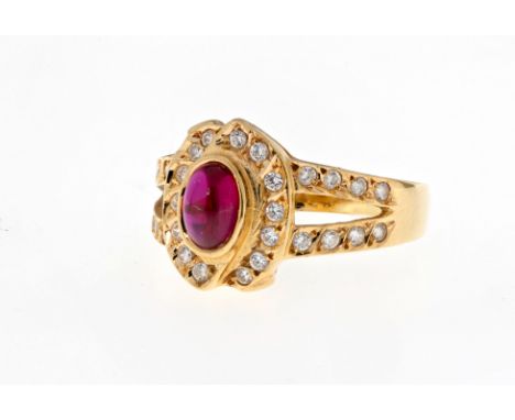 A Portuguese gold and ruby ring, featuring a central cabochon ruby measuring approximately 6x4.5mm and held in a stylised bez